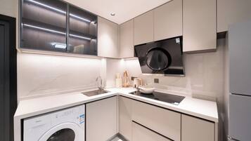 Une cuisine moderne équipée d’un lave-linge, d’un four à micro-ondes et d’un réfrigérateur.