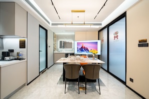 Une chambre d’hôtel moderne dotée d’un coin repas, d’un téléviseur à écran plat et offrant une vue sur les montagnes.