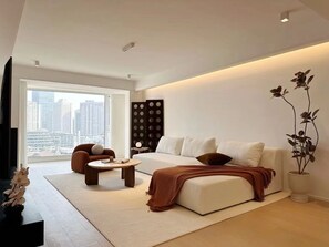 A modern living room with a sofa, two armchairs, a coffee table, and a large window offering a city view. - Shijia Homestay - Shanghai Century (Shanghai)