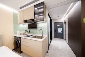 A compact kitchen with a sink, stove, and microwave. - Shijia Homestay (Shanghai Lujiazui Century Avenue Branch) (Shanghai)