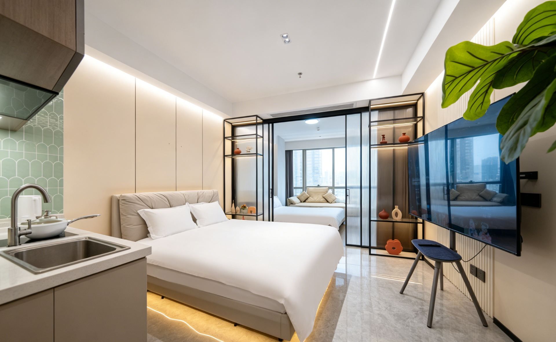 A modern hotel room with a bed, a TV, a desk with a sink, and a large window.