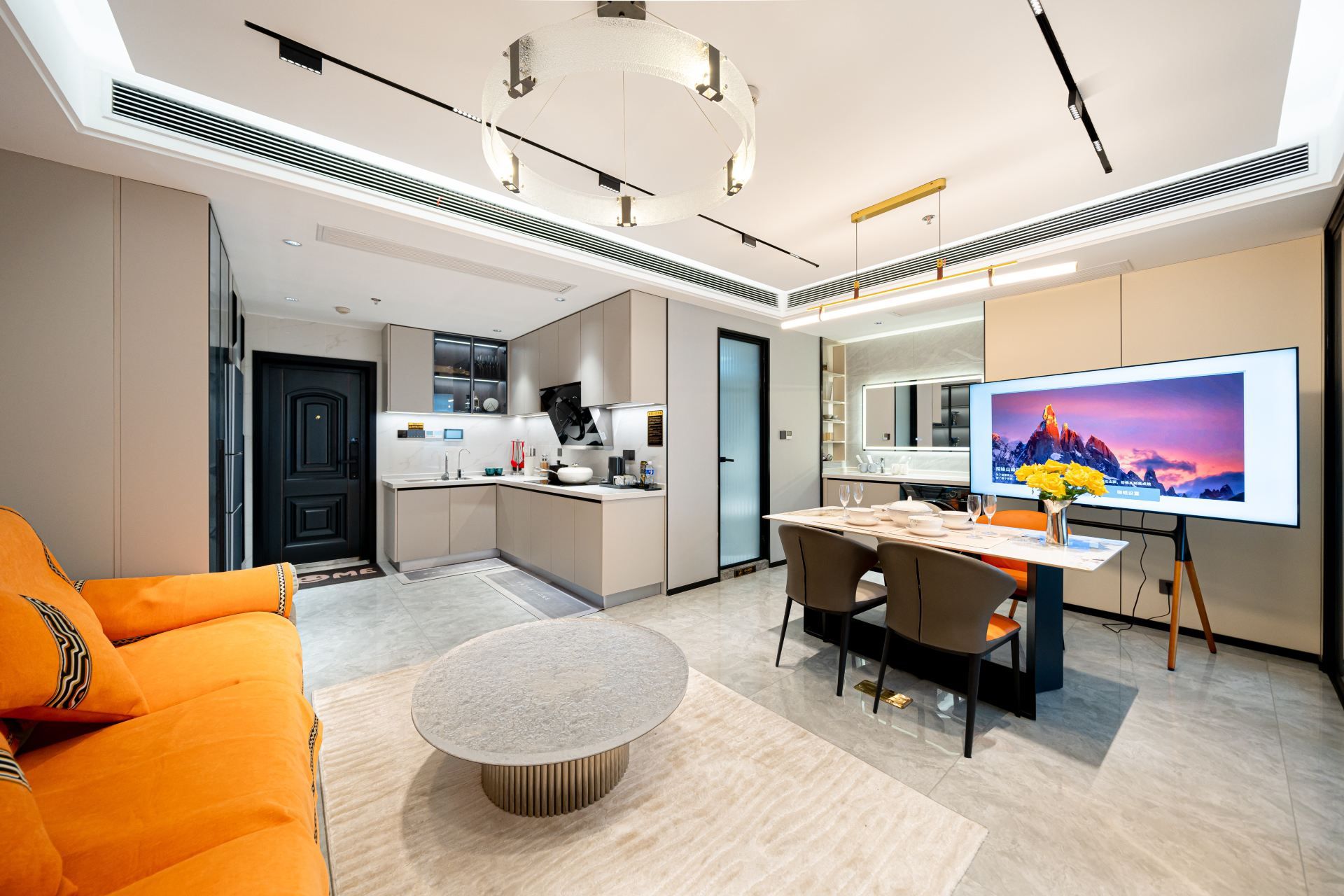 Habitación de hotel moderna con comedor, televisión y cocina.