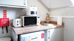 Eine Küchenzeile mit einer Mikrowelle, einem Toaster und einem Kühlschrank.