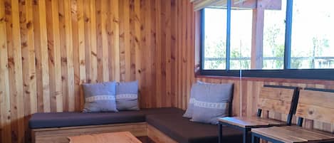 A wooden interior with a built-in bench and a small table.