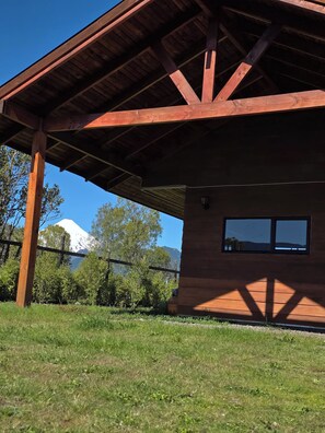 Un edificio de madera con techo inclinado, una ventana y vista a la montaña.