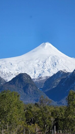 A snow-capped mountain with a clear sky. - Cabañas don Agustín Pucón  (Pucón)