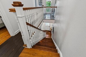 A staircase with white balusters and wooden handrails leading to a landing. - Perfect location! Huge, historic & updated home, easy stroll to downtown St. Aug (St. Augustine)