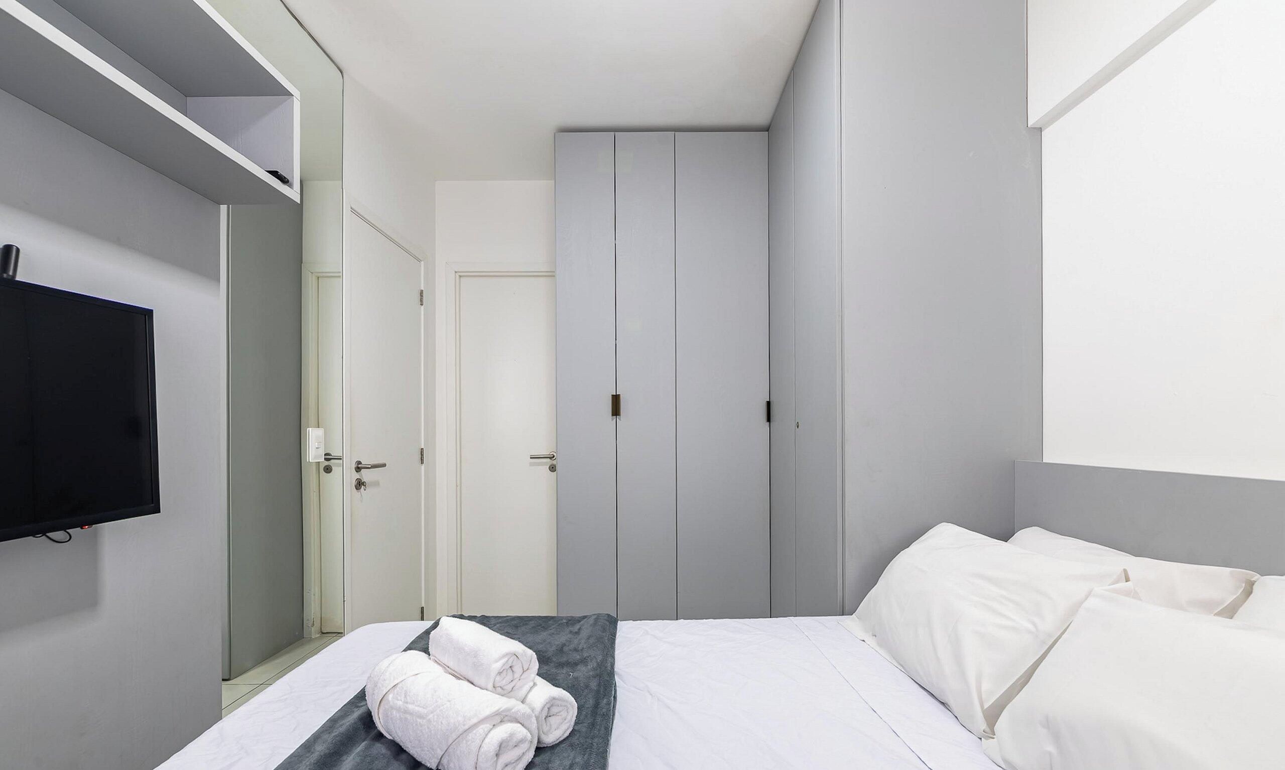 Una habitación de hotel con cama, televisor, armario y baño.