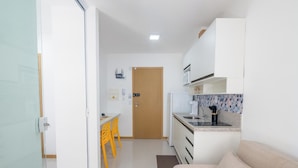 A compact kitchen with a microwave, stove, and sink. - Apt in Condo w/ Pool in Federacao Hfo1006 (Salvador)