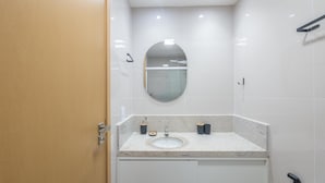 A modern bathroom with a sink, mirror, and towel rack. - Apt in Condo w/ Pool in Federacao Hfo1006 (Salvador)