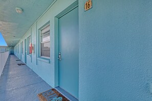 Un pasillo con puertas numeradas 16, 17 y 18, que conduce a habitaciones individuales.