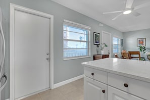 A kitchen with white cabinetry, a countertop, and a ceiling fan. - OUTSTANDING Location!  High-end 2/1 On The Beach, Close To The Port & Pier! (Cocoa Beach)