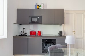 A compact kitchen with a microwave, toaster, and coffee maker. - Authentic Prati Penthouse (Rome)