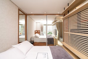 A modern hotel room with a large bed, a wooden wardrobe, and a view of the city through the window. - Flat in Full Condo, Setor Bueno - Txp0903 (Goiânia)