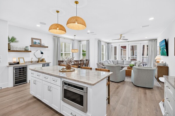 A modern kitchen with a central island, built-in appliances, and a dining area with a sofa and chairs.