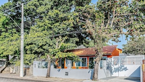 Un immobile residenziale con cancello privato, un piccolo garage annesso e una casa con tetto rosso.