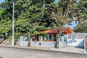 A residential property with a gated entrance, a small attached garage, and a house with a red roof. - Cozy Studio Facing the Lagoon Sdr007 (Florianópolis)