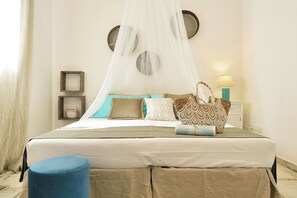 A neatly arranged bedroom with a bed, bedside tables, a nightstand, and a lamp. - Villa Alexandra Sicilymyhome (Ispica)
