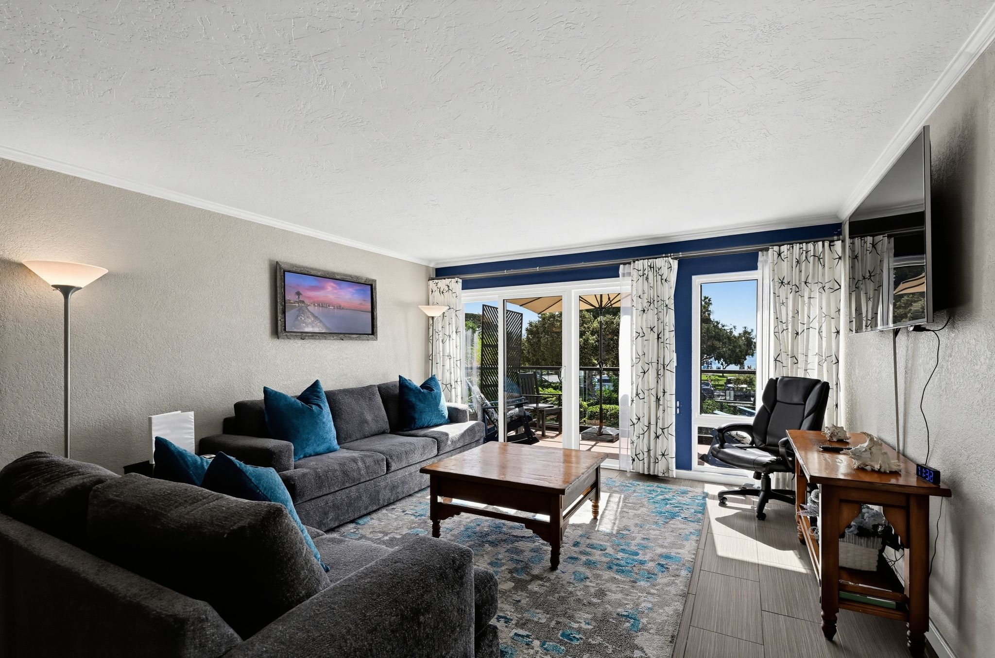 Living room with plush seating, wood coffee table, and sliding doors to the patio.