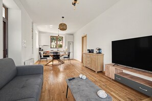 A modern living room with a grey sofa, a coffee table, and a flat-screen TV. - Villa 'Muralis Mare' with Sea View, Wi-Fi and Air Conditioning (Λυγιά)