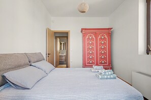A bedroom with a bed, pillows, a wardrobe, and a hanging light fixture. - Villa 'Muralis Mare' with Sea View, Wi-Fi and Air Conditioning (Λυγιά)
