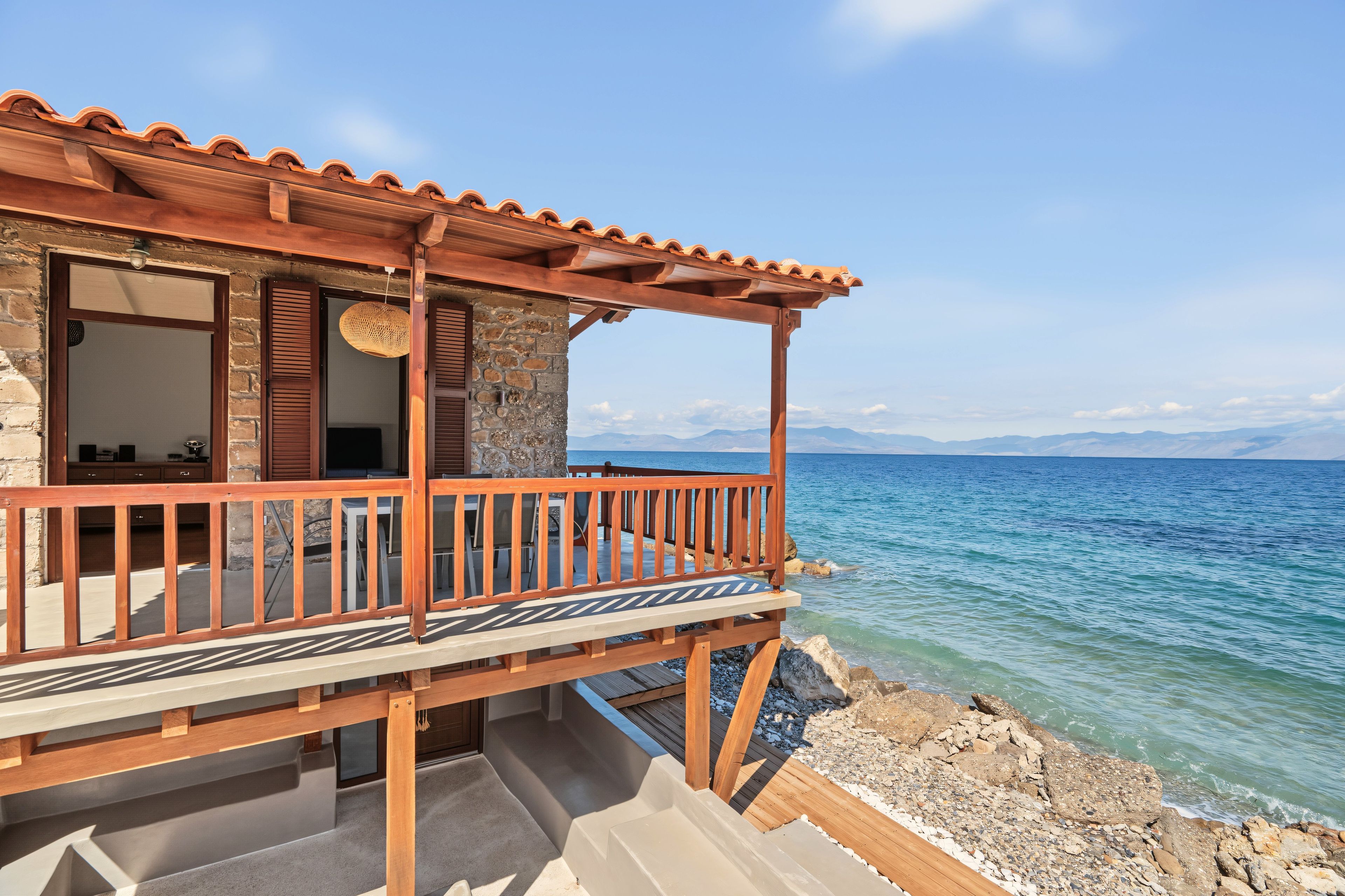 A coastal building with a wooden balcony overlooking the sea.