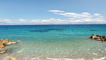 A clear coastal view with rocky shores and calm sea.