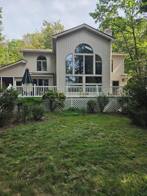 A two-story house with a white picket fence, a covered patio, and a well-maintained lawn. - Spacious 4-bedroom house in adorable Pocono Lake with AC (Pocono  lake)
