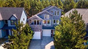 Ein zweigeschossiges Haus mit Garage, umgeben von Bäumen.