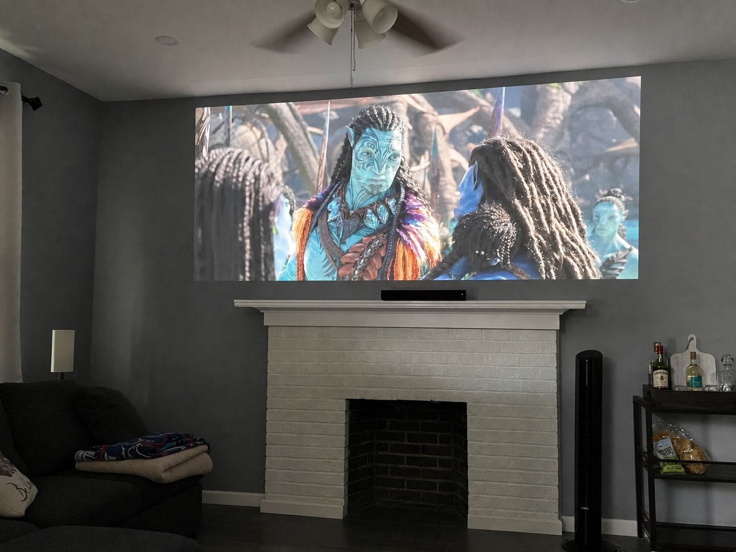 A living room with a flat-screen TV mounted above a white brick fireplace.