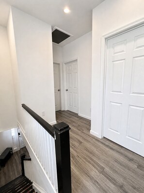 Un escalier avec une rampe noire menant à un palier.