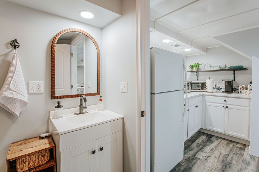 A modern kitchen with white cabinets, a stainless steel refrigerator, and a microwave.