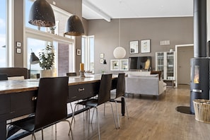 Una cucina moderna con isola in legno, illuminazione a sospensione e piano cottura integrato.