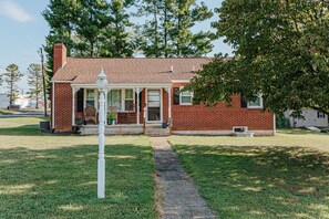 A brick house with a porch and a white lamp post.