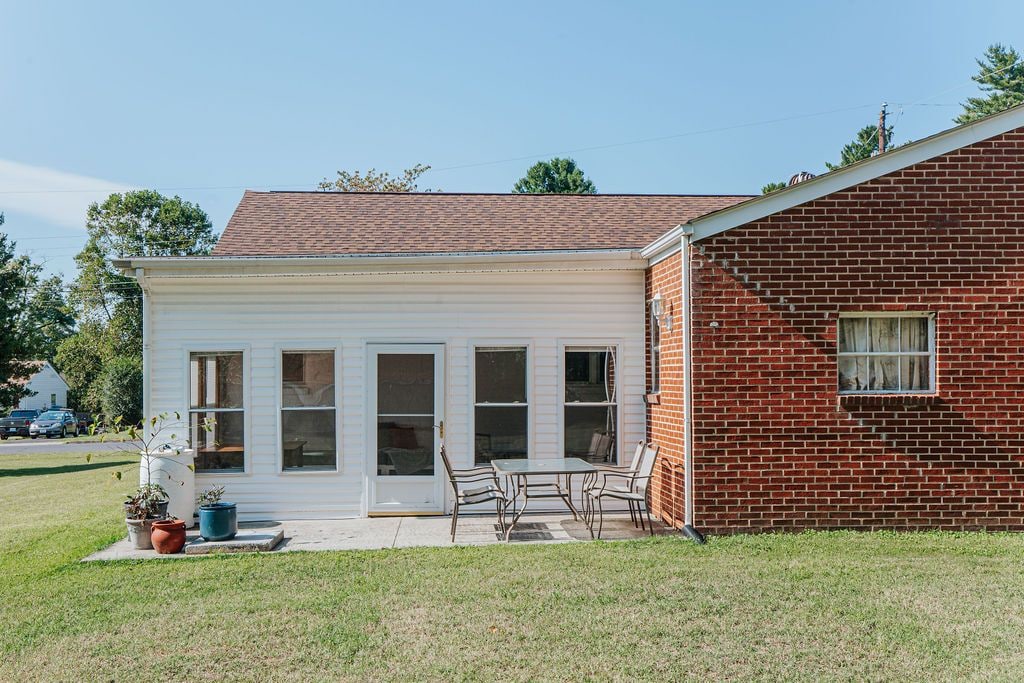 A two-story house with a covered patio, a brick exterior, and a garage.
