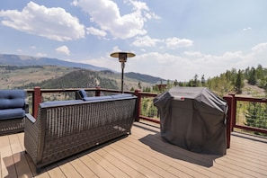 A deck with outdoor furniture, a covered grill, and a view of a mountainous landscape. - Secluded private home with incredible views (Silverthorne)