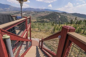 A staircase leading to a viewing platform with metal railings and a clear view of a mountainous landscape. - Secluded private home with incredible views (Silverthorne)