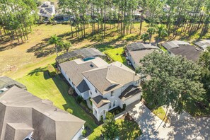 A residential area with multiple houses, each featuring a sloped roof and surrounded by greenery. - Bright & Spacious 6BR Near Disney w/Pool (Davenport)