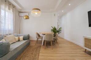 Una sala de estar moderna con sofá, mesa de comedor y sillas.