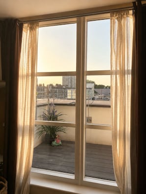 A room with a large window, curtains, a small balcony with a plant and a toy car. - Luxury Marylebone Penthouse (London)