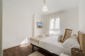 A bedroom with a bed, a window with curtains, a painting on the wall, and a ceiling light. - Apartment in downtown Getafe (Getafe)