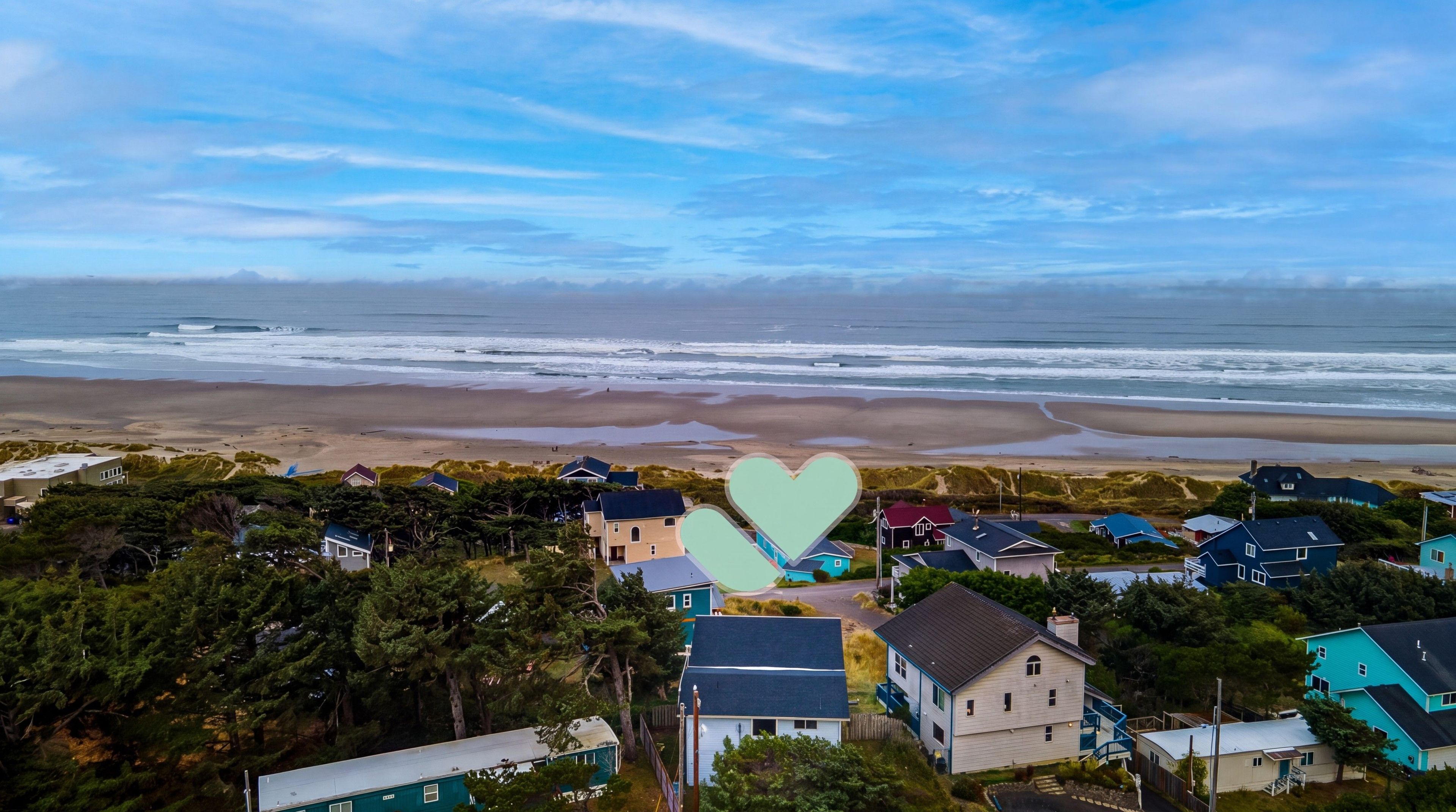 A coastal residential area with houses, a beach, and a view of the ocean.