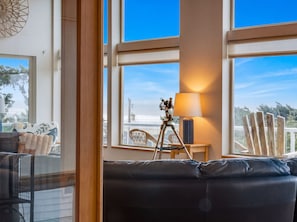 A room with a large window, a telescope, a lamp, and a sofa. - Sunset Port at Heceta Beach *Great Views* (Florence)