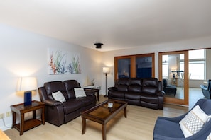 A living room with leather sofas, a coffee table, and artwork on the wall. - Sunset Port at Heceta Beach *Great Views* (Florence)