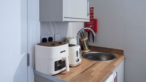 Eine Küchenzeile mit einem GEEPAS-Toaster, einem Wasserkocher, einer Spüle und einer Brandschutzdecke.