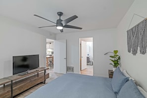 A bedroom with a bed, a TV, a ceiling fan, and a plant. - 1BR Condo for 4 w/Hot Tub, Near Shuttle & Shopping (Mammoth Lakes)