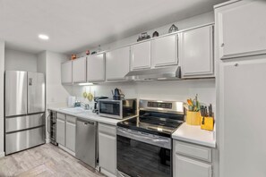 A modern kitchen with stainless steel appliances, white cabinetry, and a wooden countertop. - 1BR Condo for 4 w/Hot Tub, Near Shuttle & Shopping (Mammoth Lakes)