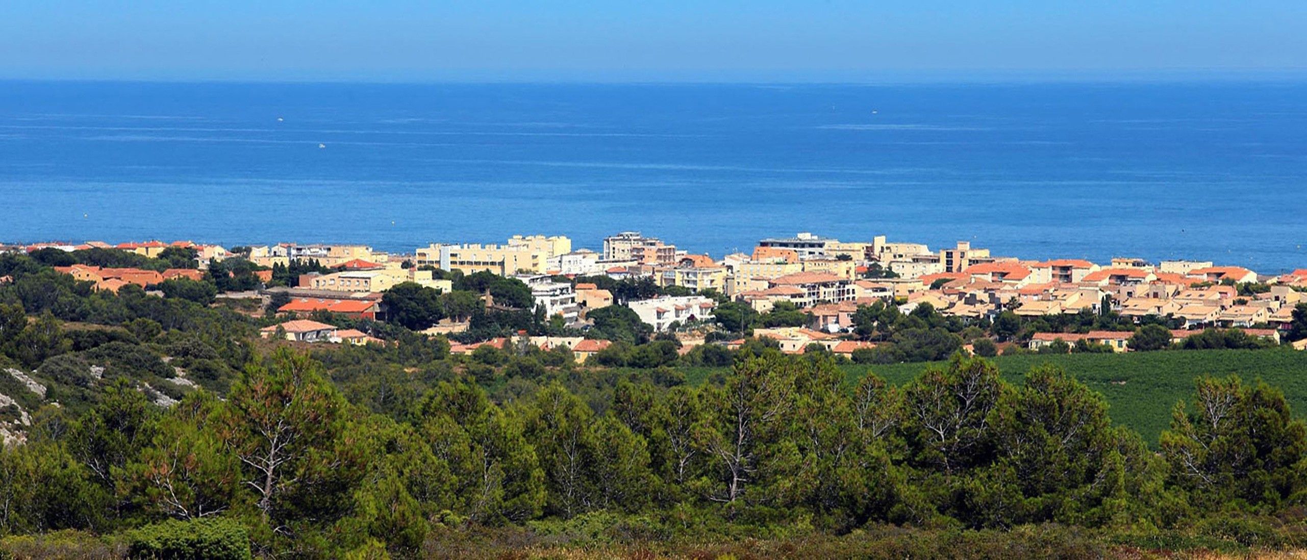 Uma vila costeira com edifícios e vista para o mar.