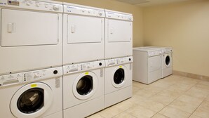 A laundry room with multiple washing machines and dryers. - Accessible Suite w/ Kitchen | Free Breakfast! (Elkhart)
