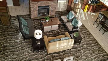 A modern living room with a fireplace, seating area, and a television mounted above it.